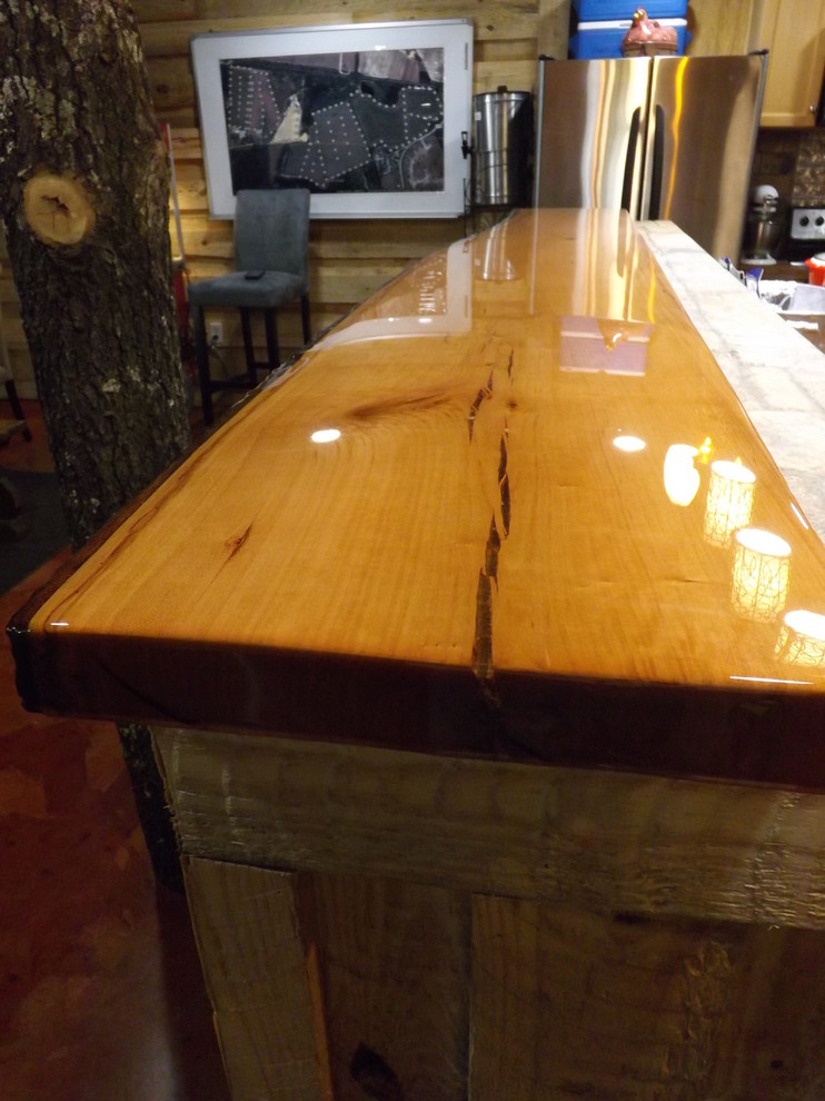 Immagine di un bancone bar rustico di medie dimensioni con top in legno, pavimento in cemento e pavimento marrone