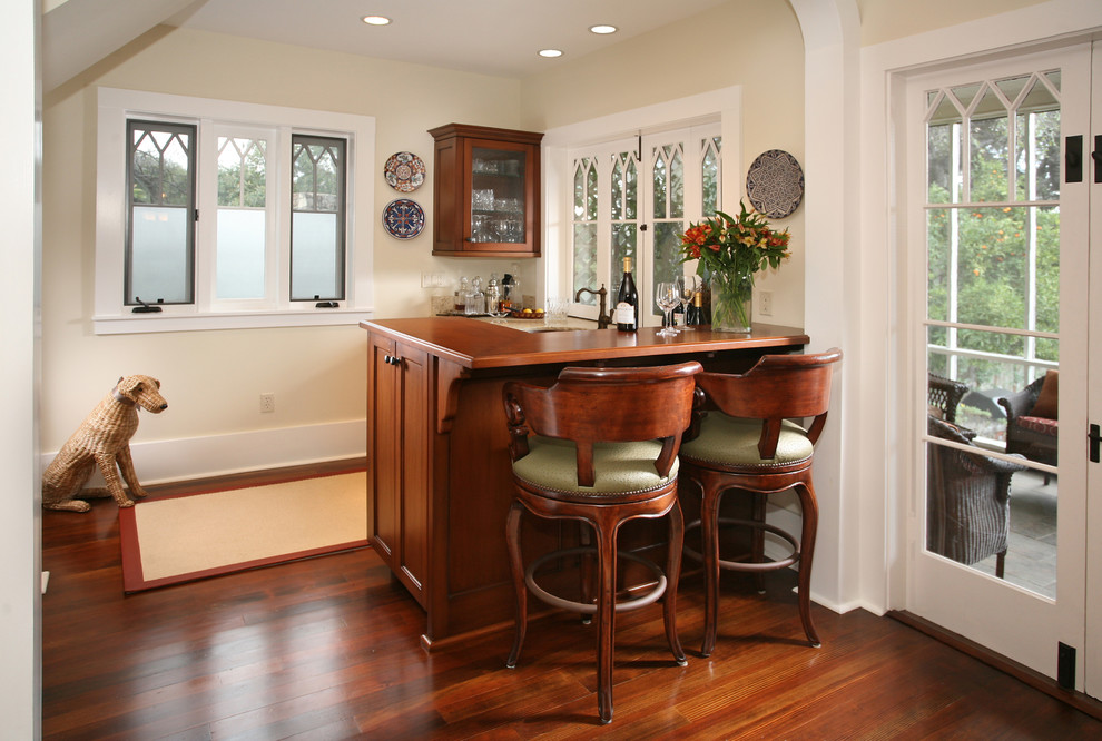 Photo of a traditional home bar in Los Angeles with shaker cabinets, dark wood cabinets and dark hardwood flooring.