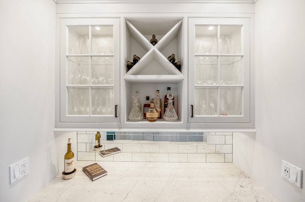 Inspiration for a small classic single-wall wet bar in New York with beaded cabinets, white cabinets, marble worktops, mirror splashback and dark hardwood flooring.