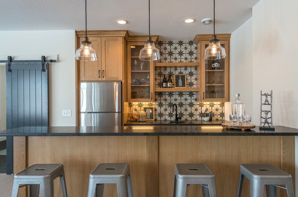 Design ideas for a traditional breakfast bar in Minneapolis with glass-front cabinets, light wood cabinets, multi-coloured splashback and black worktops.