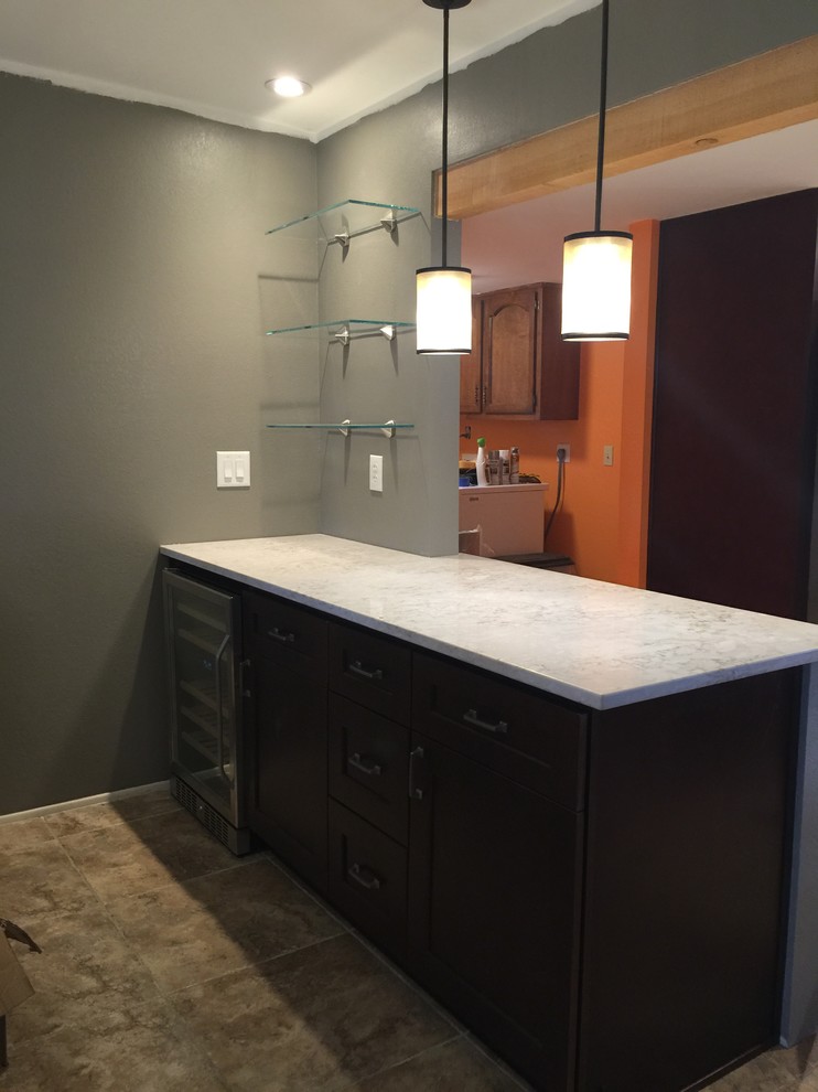 Photo of a medium sized traditional single-wall wet bar in Phoenix with no sink, recessed-panel cabinets, dark wood cabinets and ceramic flooring.