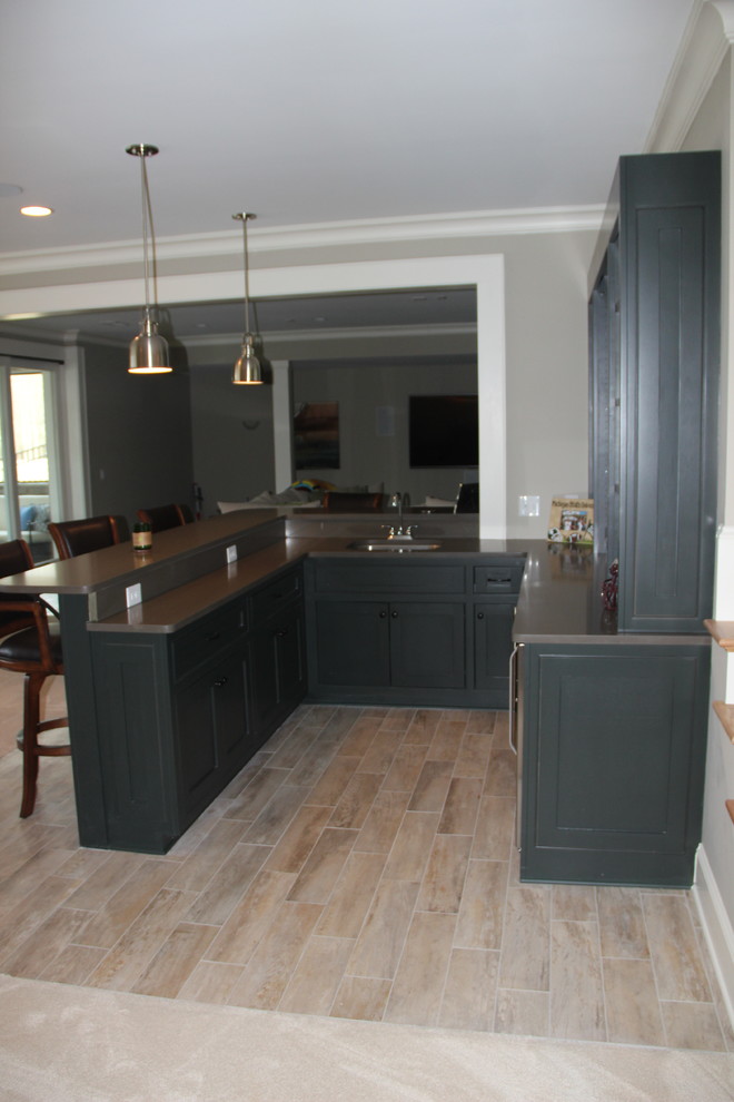 Photo of a medium sized contemporary u-shaped breakfast bar in Other with green cabinets, light hardwood flooring and shaker cabinets.