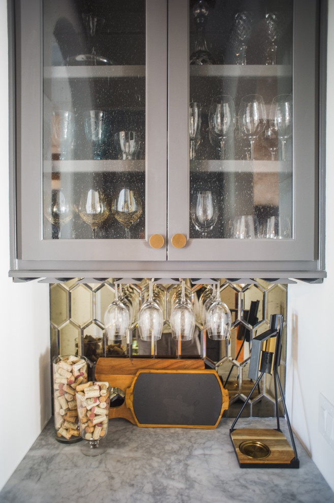 Diseño de bar en casa con fregadero lineal clásico pequeño sin pila con armarios tipo vitrina, puertas de armario grises, encimera de cemento, salpicadero con efecto espejo y encimeras grises