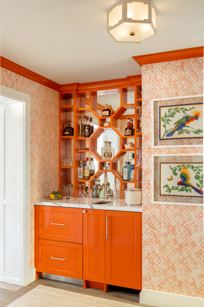 Imagen de bar en casa con fregadero lineal costero con fregadero bajoencimera, puertas de armario naranjas, salpicadero con efecto espejo y encimeras blancas