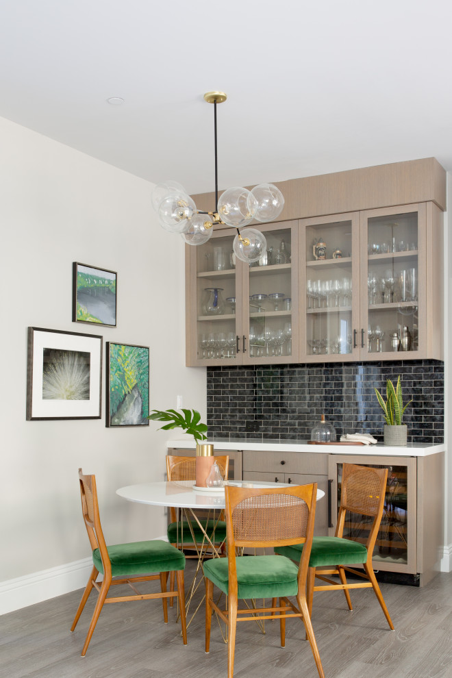 This is an example of a medium sized classic single-wall breakfast bar in San Francisco with flat-panel cabinets, engineered stone countertops, beige cabinets, black splashback, glass tiled splashback, grey floors and white worktops.
