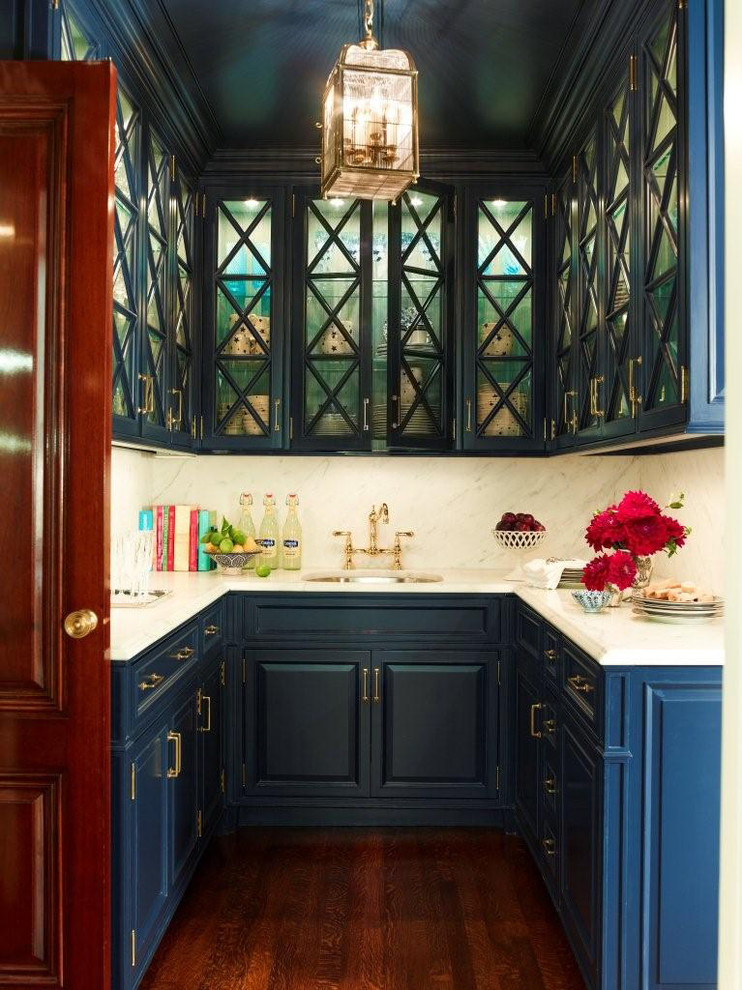 Mid-sized elegant u-shaped dark wood floor wet bar photo in New York with an undermount sink, raised-panel cabinets, white backsplash, stone slab backsplash, white countertops and blue cabinets