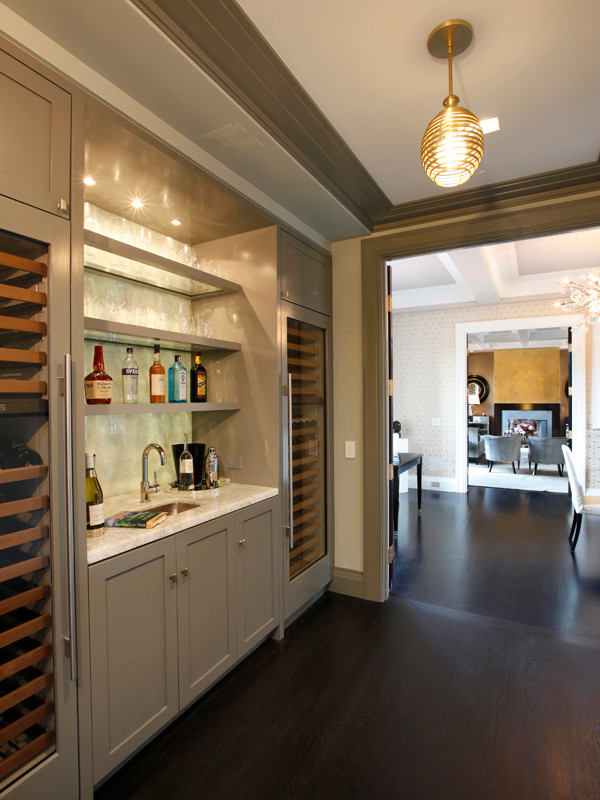 This is an example of a medium sized contemporary single-wall wet bar in New York with a submerged sink, recessed-panel cabinets, grey cabinets, marble worktops, white splashback and dark hardwood flooring.