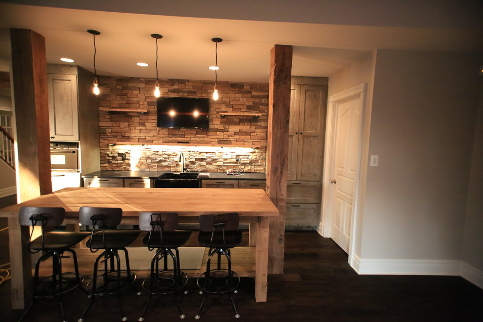 Imagen de bar en casa con fregadero lineal con salpicadero beige, salpicadero de azulejos de piedra y suelo de madera oscura
