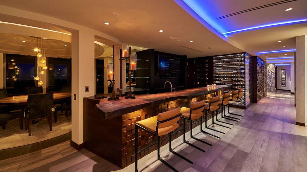 Idée de décoration pour un grand bar de salon avec évier parallèle design en bois foncé avec un plan de travail en bois, parquet clair et un sol gris.