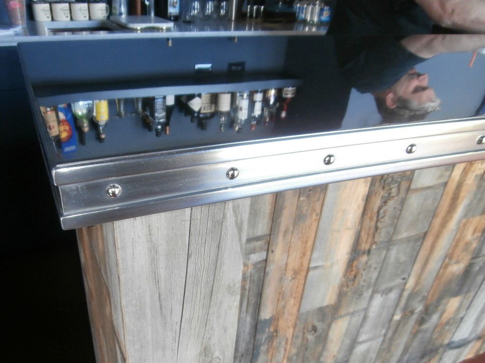 Foto de bar en casa con barra de bar en L rústico grande con armarios con paneles lisos, puertas de armario con efecto envejecido, encimera de zinc y salpicadero de travertino