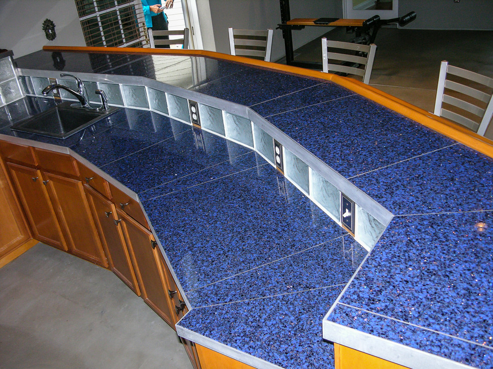 Diseño de bar en casa con barra de bar de galera ecléctico de tamaño medio con encimera de vidrio reciclado, suelo de cemento y suelo marrón