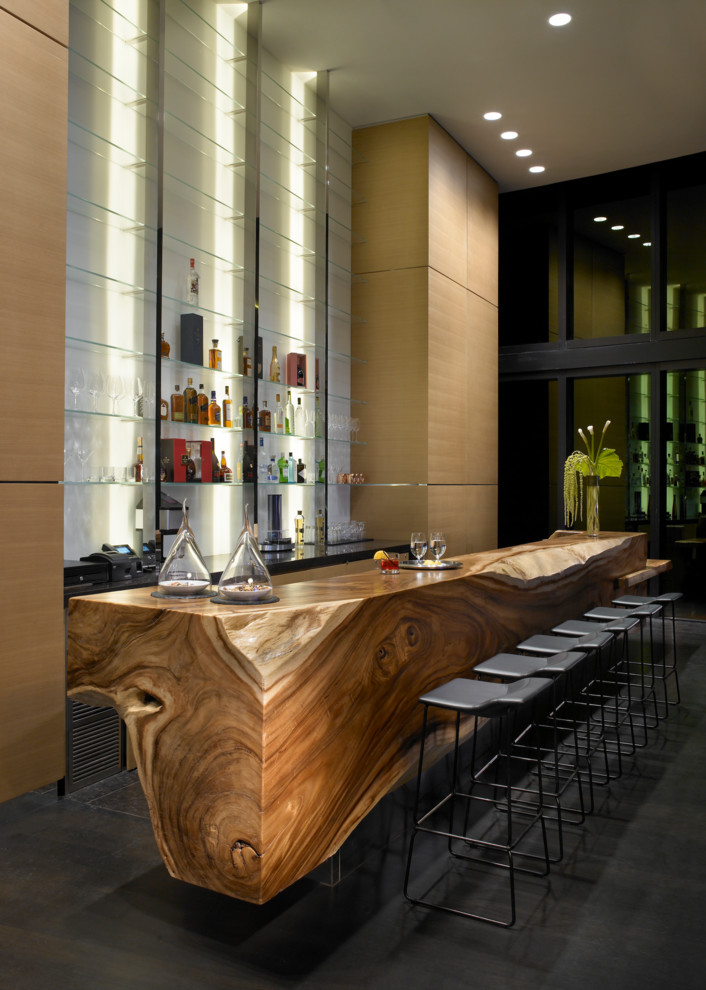 Стильный дизайн: огромный параллельный домашний бар в стиле модернизм с барной стойкой, открытыми фасадами, деревянной столешницей, белым фартуком, фартуком из стекла, серым полом и коричневой столешницей - последний тренд