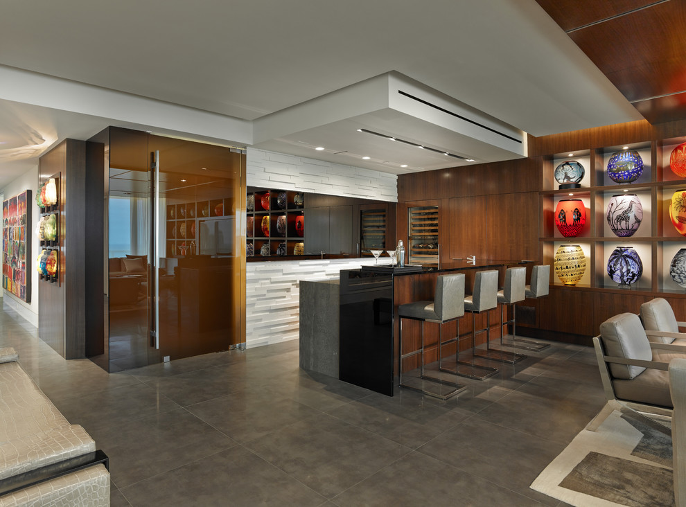 Diseño de bar en casa con barra de bar en L actual de tamaño medio con encimera de ónix y suelo de cemento