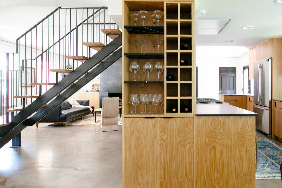Moderne Hausbar mit offenen Schränken, hellbraunen Holzschränken, Betonboden und grauem Boden in Austin