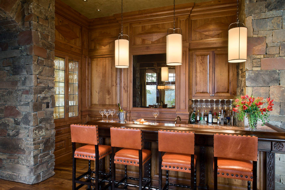 Idées déco pour un bar de salon montagne en U et bois foncé avec parquet foncé, des tabourets et un placard avec porte à panneau surélevé.