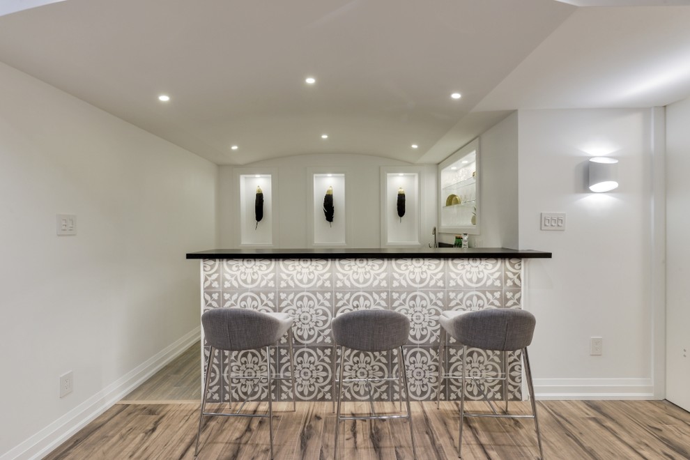 This is an example of a large contemporary l-shaped wet bar in Toronto with a built-in sink, flat-panel cabinets, white cabinets, wood worktops, black splashback, wood splashback, porcelain flooring and grey floors.