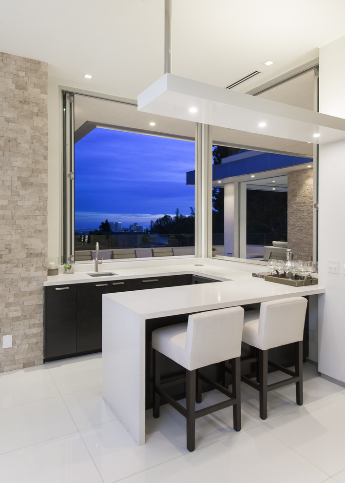 Photo of a contemporary u-shaped breakfast bar in Los Angeles with a submerged sink, flat-panel cabinets and dark wood cabinets.