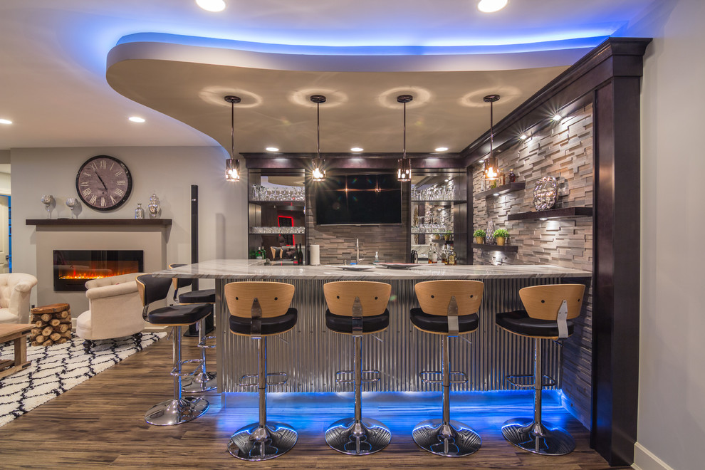 Immagine di un bancone bar contemporaneo con paraspruzzi grigio, parquet scuro e pavimento marrone
