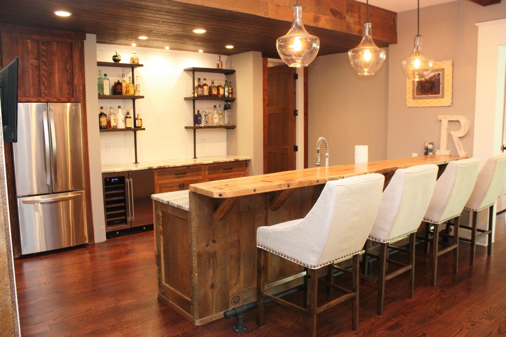 Modelo de bar en casa con barra de bar de galera rústico de tamaño medio con armarios estilo shaker, puertas de armario marrones, encimera de granito y encimeras multicolor