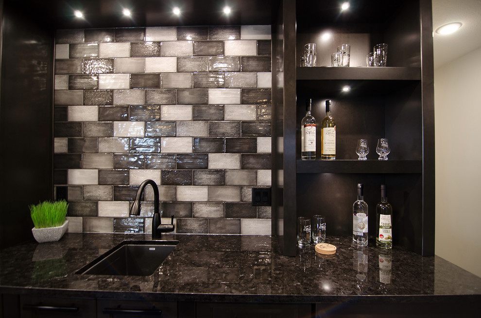 Example of a mid-sized trendy single-wall dark wood floor and brown floor wet bar design in Other with an undermount sink, recessed-panel cabinets, dark wood cabinets, granite countertops, multicolored backsplash, subway tile backsplash and black countertops