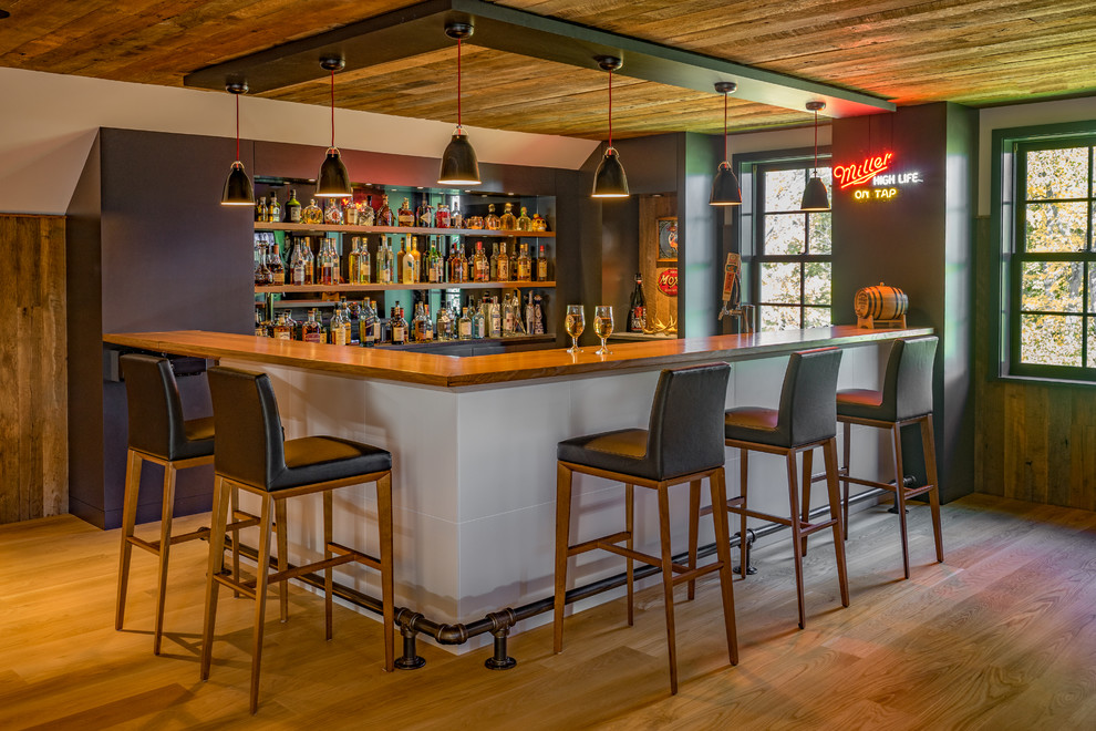Immagine di un angolo bar contemporaneo con top in legno, paraspruzzi a specchio, pavimento in legno massello medio, pavimento marrone e top marrone