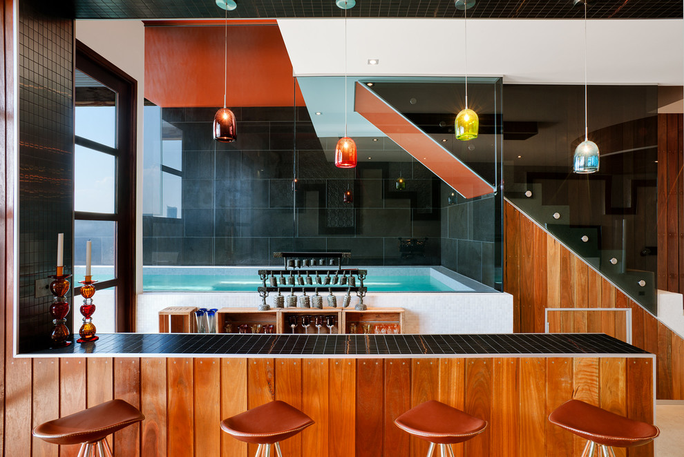 На фото: прямой домашний бар в современном стиле с барной стойкой и коричневыми фасадами
