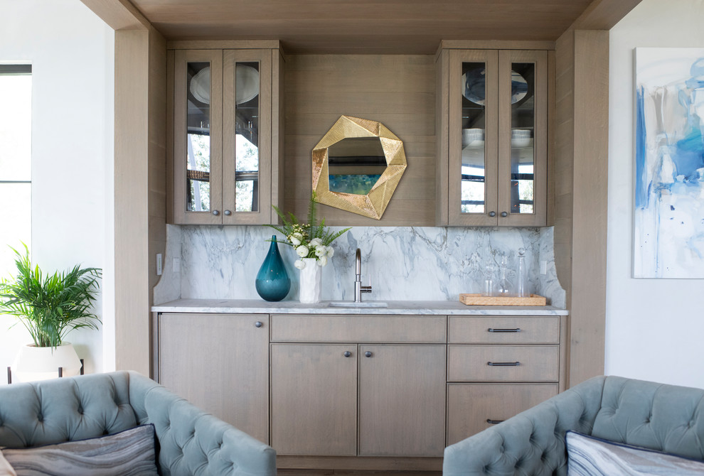 Esempio di un angolo bar con lavandino stile marino con lavello sottopiano, ante di vetro, ante in legno chiaro, top in marmo, paraspruzzi bianco, paraspruzzi in marmo e top bianco