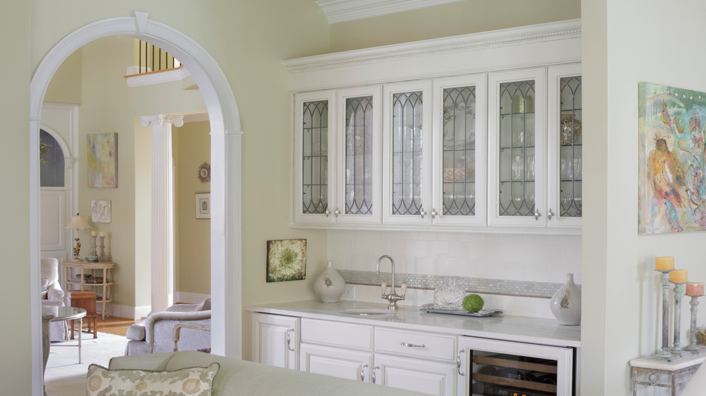 Bild på en mellanstor lantlig linjär hemmabar med vask, med luckor med upphöjd panel, vita skåp, marmorbänkskiva, vitt stänkskydd, stänkskydd i mosaik, ljust trägolv och en undermonterad diskho