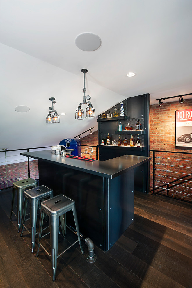 Réalisation d'un bar de salon urbain avec des tabourets, des portes de placard noires et parquet foncé.