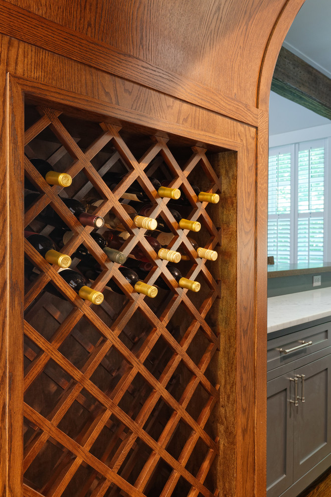 This is an example of a traditional wine cellar in Cincinnati with brown floors and medium hardwood flooring.