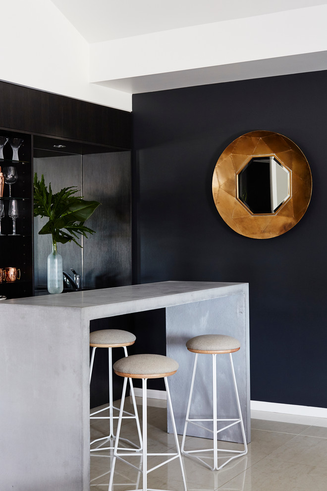 Diseño de bar en casa con barra de bar de galera, actual, con armarios abiertos, puertas de armario negras y encimera de cemento