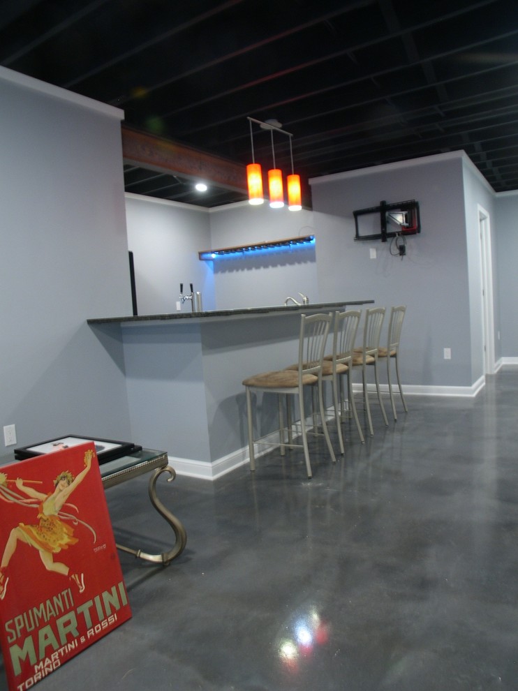 Photo of a large bohemian home bar in Other with concrete flooring.