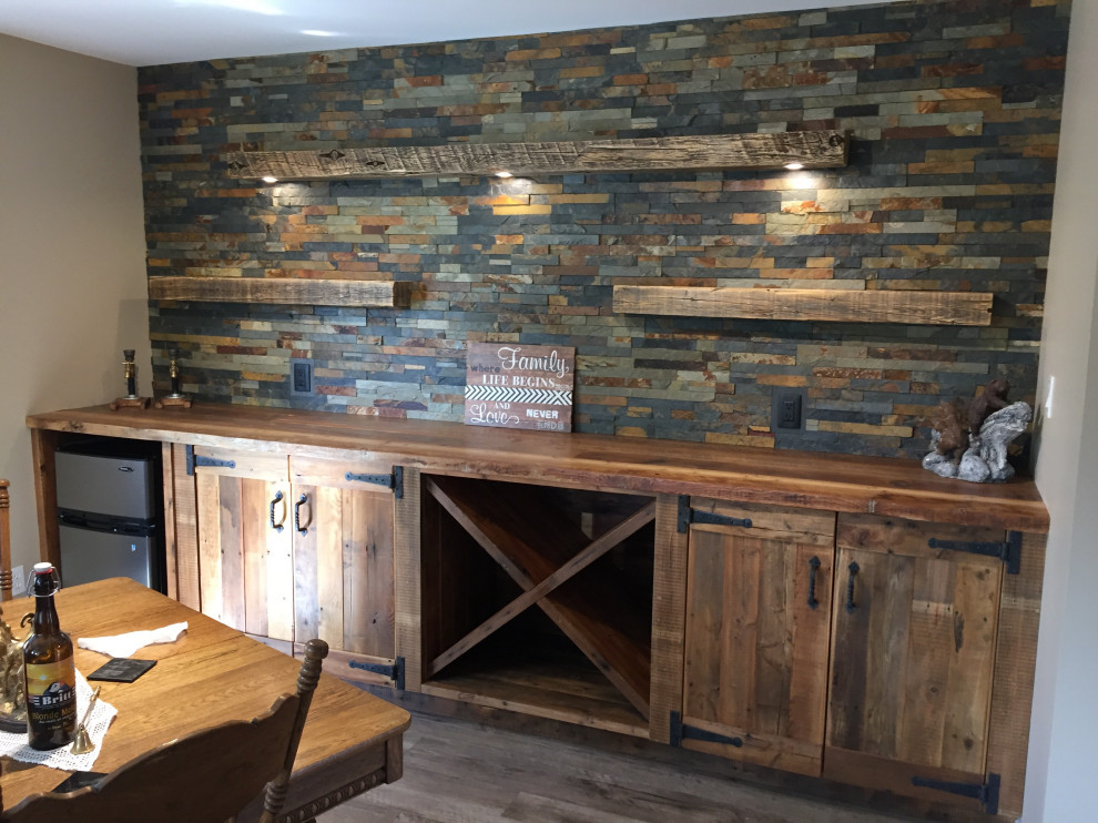 エドモントンにあるラスティックスタイルのおしゃれなホームバー (ヴィンテージ仕上げキャビネット、木材カウンター、マルチカラーのキッチンパネル、石タイルのキッチンパネル、ラミネートの床、茶色いキッチンカウンター) の写真