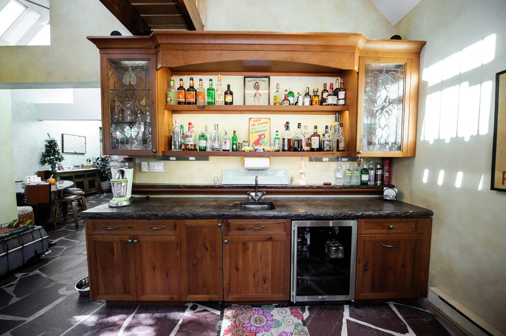 Cette photo montre un bar de salon avec évier parallèle montagne en bois brun de taille moyenne avec un évier encastré, un placard à porte shaker, un plan de travail en béton, une crédence multicolore et un sol en ardoise.