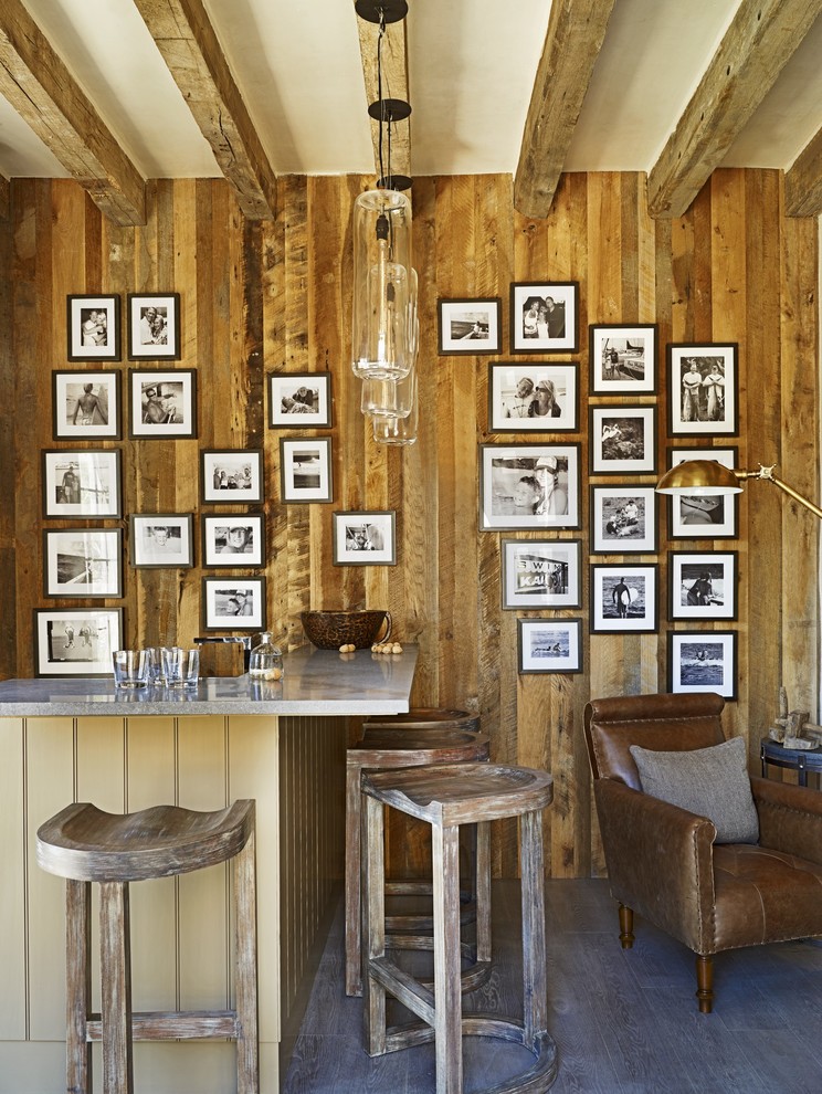 Cette photo montre un bar de salon montagne avec des tabourets, un sol en bois brun et un sol gris.