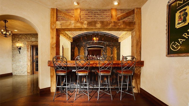Exemple d'un bar de salon linéaire montagne en bois foncé de taille moyenne avec des tabourets.