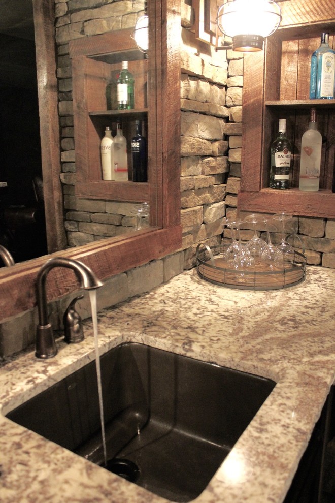 Immagine di un bancone bar stile rurale di medie dimensioni con lavello sottopiano, paraspruzzi marrone, paraspruzzi con piastrelle in pietra, pavimento in gres porcellanato, pavimento marrone, top in granito e top beige