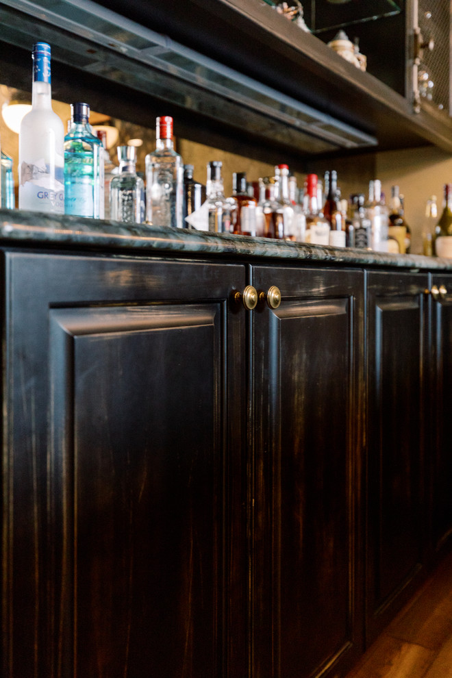 Photo of a large classic u-shaped breakfast bar in Milwaukee with raised-panel cabinets, black cabinets, marble worktops, medium hardwood flooring, black floors and multicoloured worktops.