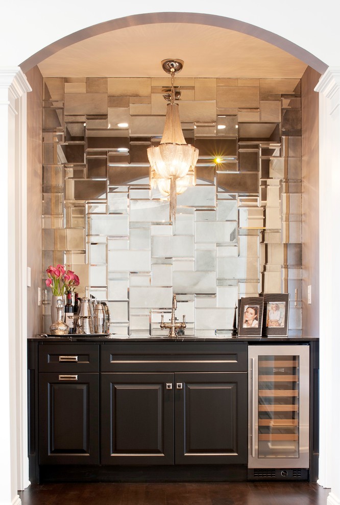 Foto di un angolo bar con lavandino minimalista di medie dimensioni con lavello sottopiano, ante con bugna sagomata, ante nere, paraspruzzi a specchio, parquet scuro e pavimento marrone