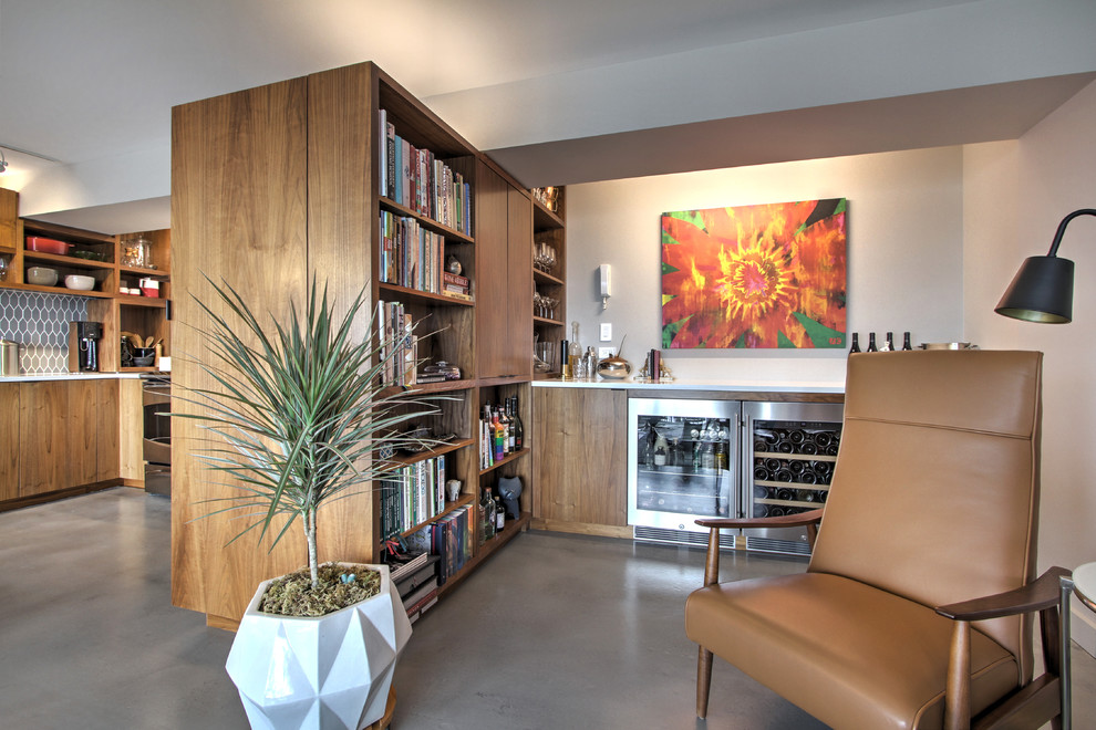 Immagine di un piccolo angolo bar con lavandino moderno con ante lisce, ante in legno bruno, top in quarzo composito, paraspruzzi bianco e pavimento in cemento
