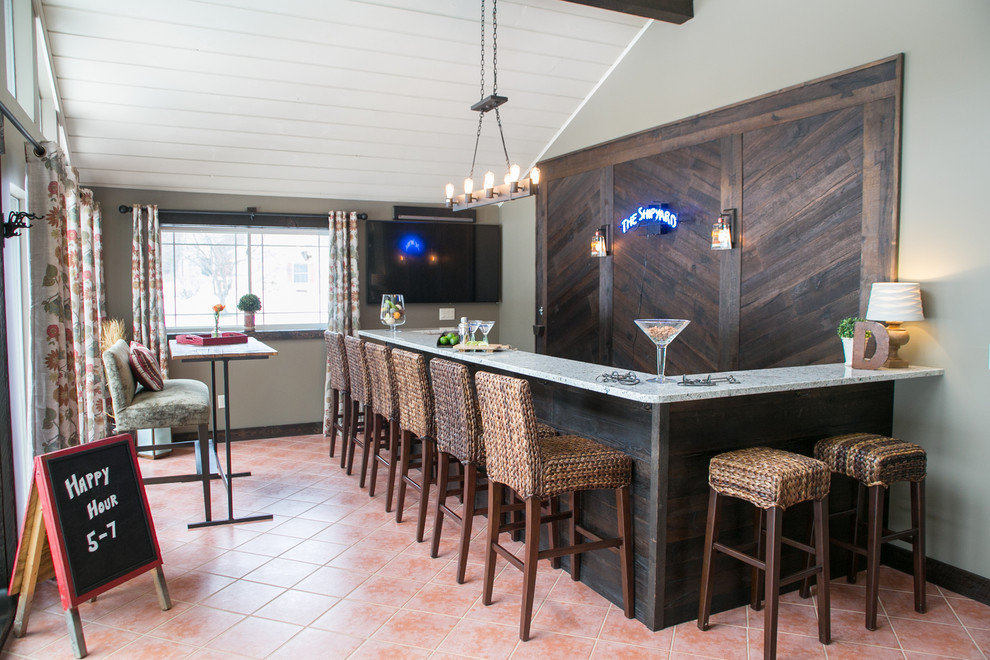На фото: угловой домашний бар среднего размера в стиле рустика с барной стойкой, гранитной столешницей, полом из керамической плитки и фартуком из дерева
