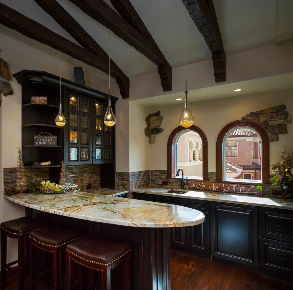 Inspiration for a mid-sized mediterranean u-shaped dark wood floor seated home bar remodel in Tampa with an undermount sink, raised-panel cabinets, dark wood cabinets, beige backsplash and matchstick tile backsplash