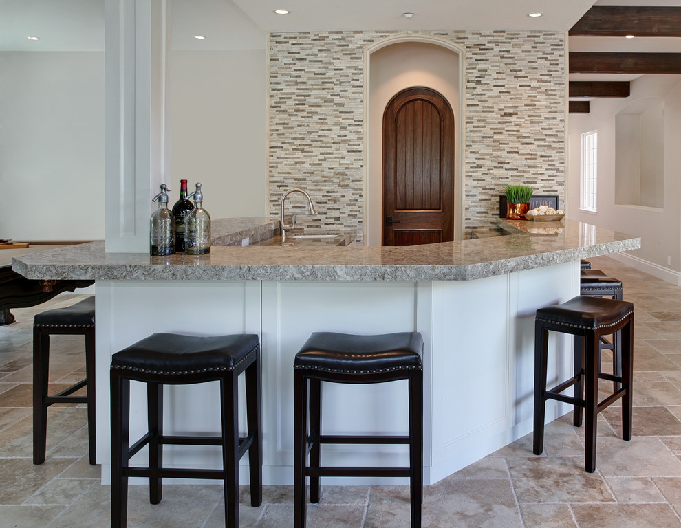 Large mediterranean breakfast bar in Orange County with a submerged sink, shaker cabinets, white cabinets, engineered stone countertops, travertine flooring and beige floors.