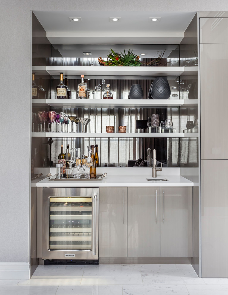 Photo of a contemporary single-wall wet bar in Miami with a submerged sink, flat-panel cabinets, grey cabinets, mirror splashback and white floors.