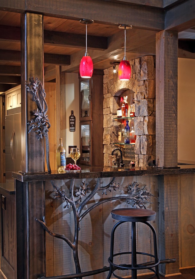 Foto di un bancone bar stile rurale con ante con bugna sagomata, ante in legno bruno e pavimento marrone