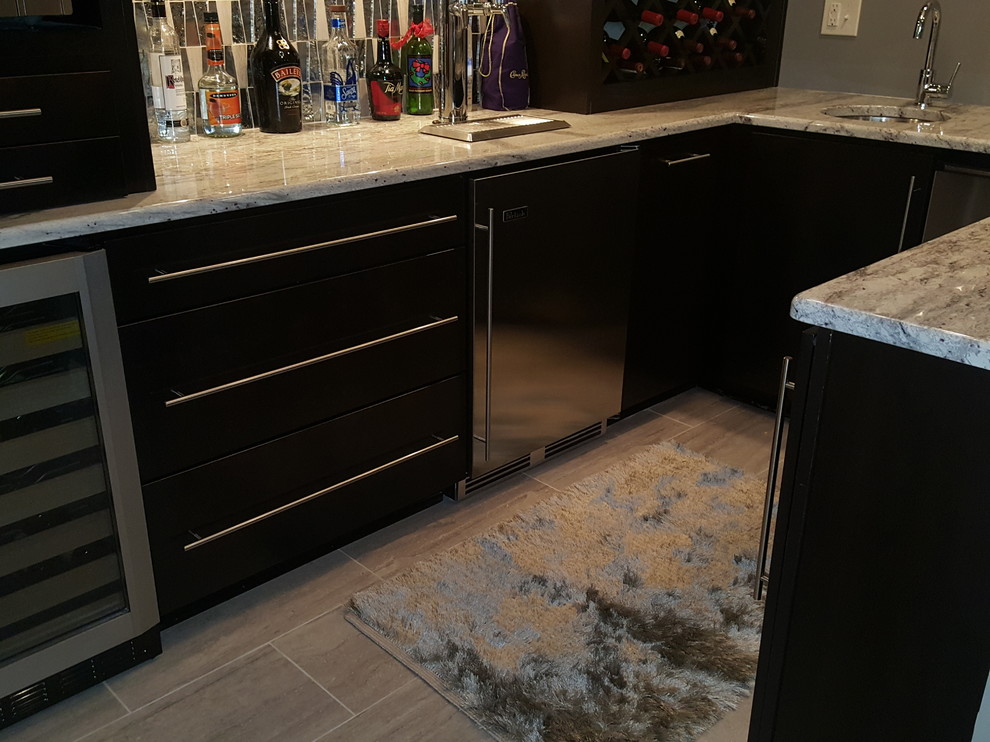 This is an example of a medium sized modern u-shaped wet bar in Indianapolis with a submerged sink, flat-panel cabinets, black cabinets, limestone worktops, grey splashback, glass tiled splashback and ceramic flooring.