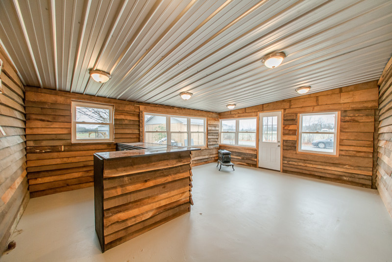 Diseño de bar en casa con barra de bar campestre de tamaño medio con encimera de cobre y suelo de cemento