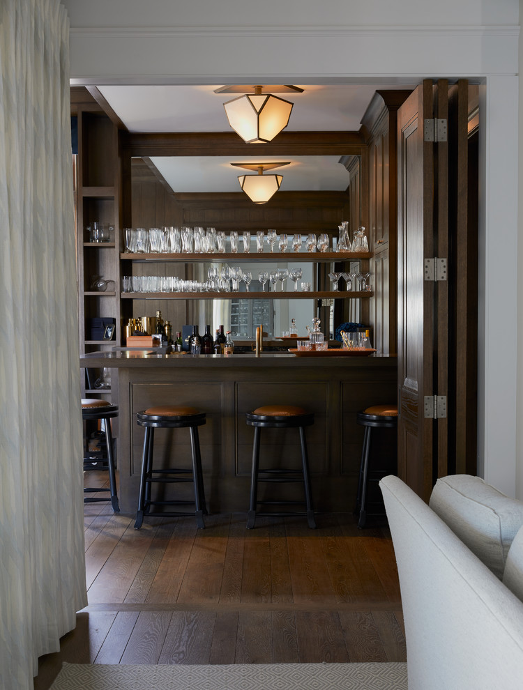 Foto di un bancone bar stile marino con nessun'anta, ante in legno bruno, paraspruzzi a specchio, parquet scuro, pavimento marrone e top marrone