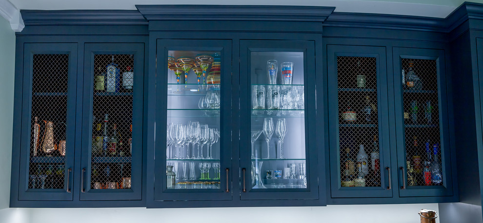 This is an example of a traditional home bar in Other with recessed-panel cabinets, blue cabinets, engineered stone countertops, white splashback, ceramic flooring, grey floors and white worktops.