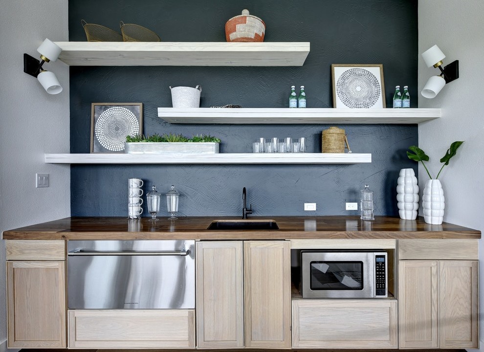Foto di un angolo bar con lavandino nordico con lavello sottopiano, ante in stile shaker, ante in legno chiaro, top in legno, paraspruzzi nero e top marrone